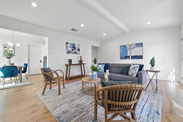 living room with a chandelier, lofted ceiling with beams, and light hardwood / wood-style floors