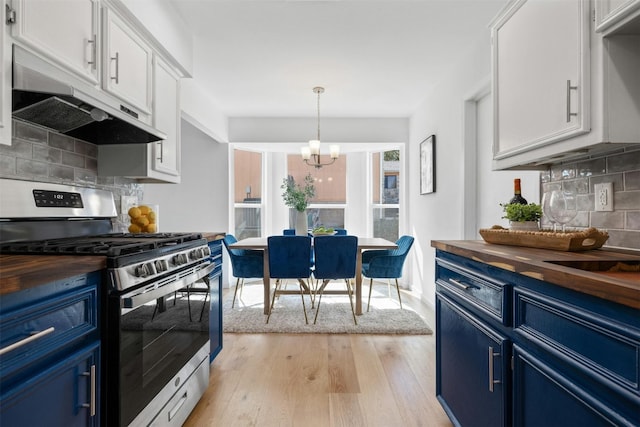 kitchen with blue cabinetry, butcher block countertops, stainless steel gas stove, and white cabinets