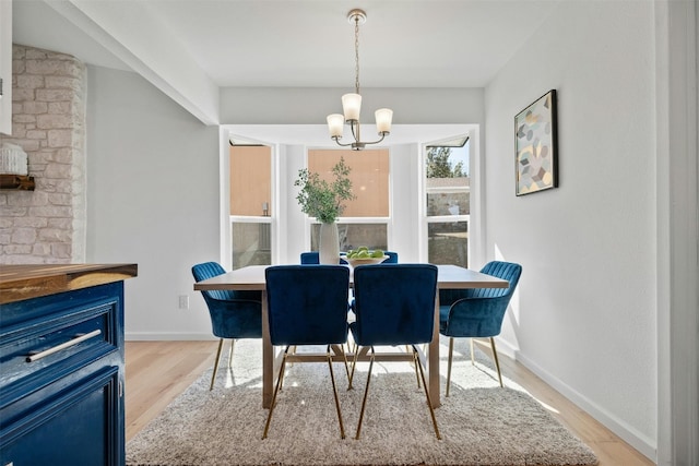 dining room with light hardwood / wood-style flooring and a chandelier