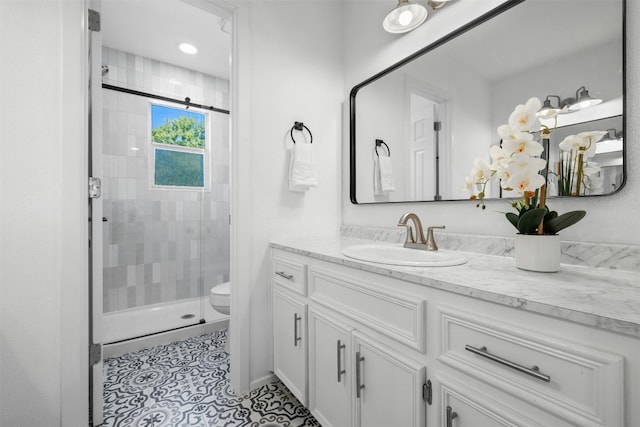 bathroom featuring vanity, an enclosed shower, toilet, and tile patterned floors