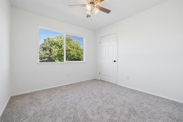 carpeted spare room featuring ceiling fan