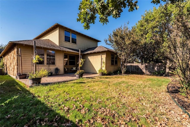 rear view of property featuring a lawn and a patio area