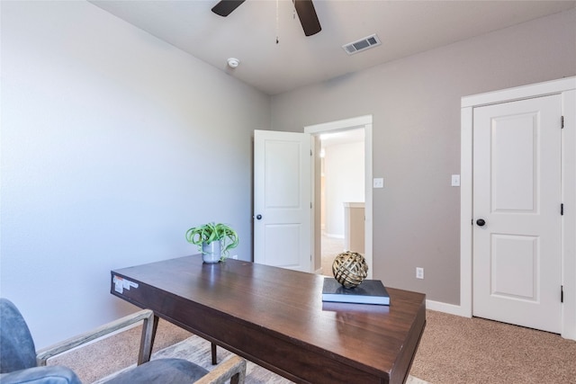 carpeted office space featuring ceiling fan