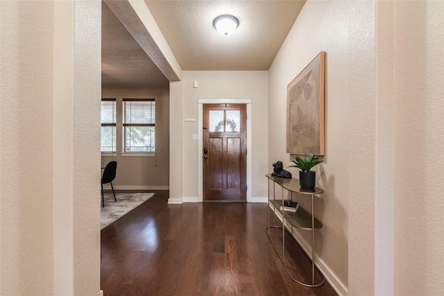 foyer with a textured ceiling and dark hardwood / wood-style flooring