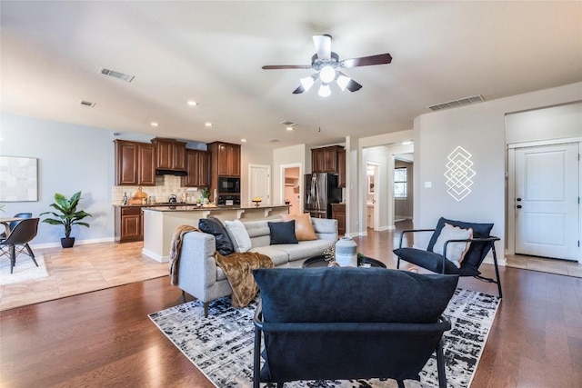 living room with ceiling fan and light wood-type flooring