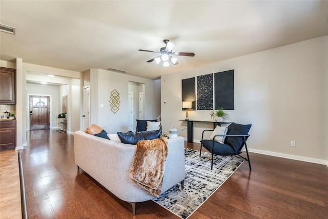 living room featuring ceiling fan and dark wood-type flooring