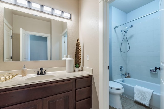 full bathroom with tile patterned flooring, tiled shower / bath combo, toilet, and vanity