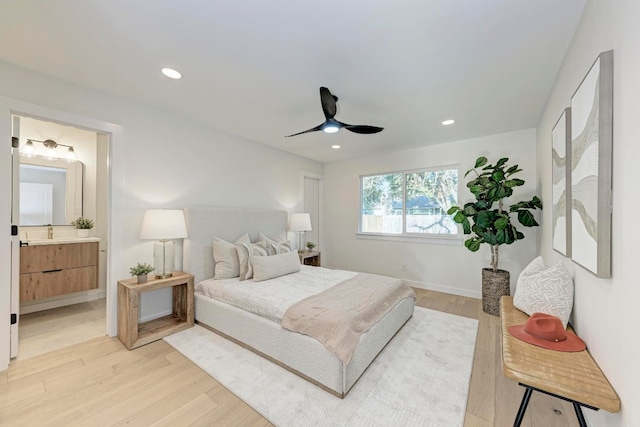 bedroom with ensuite bathroom, ceiling fan, and light hardwood / wood-style floors