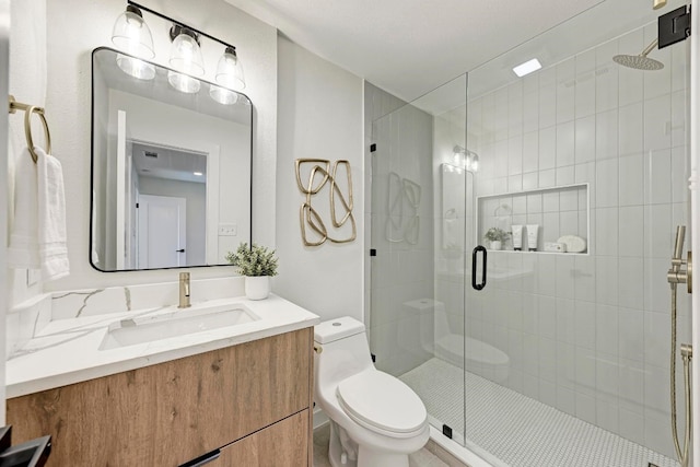 bathroom featuring vanity, toilet, and an enclosed shower