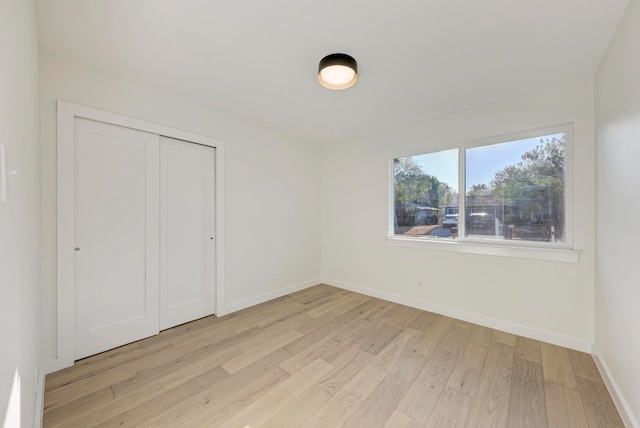 unfurnished bedroom with light hardwood / wood-style floors and a closet