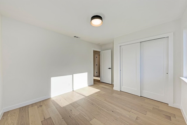 unfurnished bedroom with light hardwood / wood-style floors and a closet