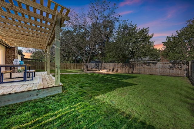 yard at dusk with a pergola and a deck