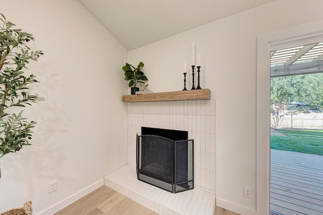 interior details with wood-type flooring and a brick fireplace