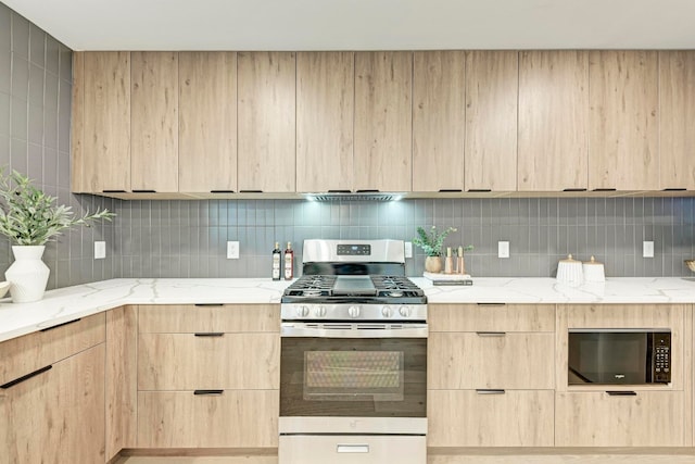 kitchen featuring light stone countertops, light brown cabinets, and stainless steel gas range