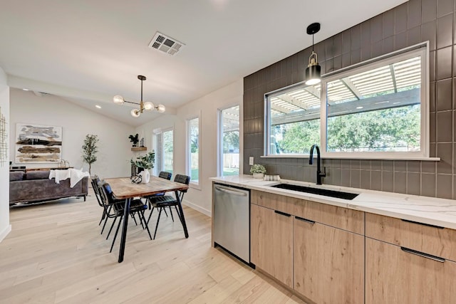 kitchen featuring dishwasher, pendant lighting, light brown cabinets, and sink