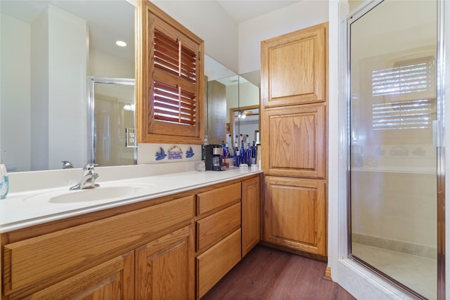 bathroom with walk in shower, hardwood / wood-style floors, and vanity