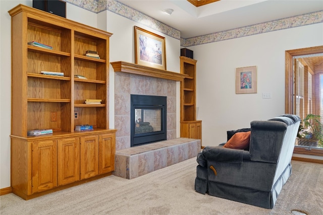 carpeted living room featuring a tiled fireplace and a wealth of natural light