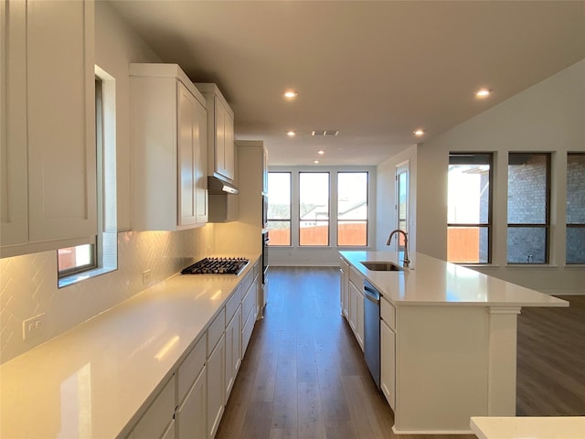 kitchen with sink, white cabinets, decorative backsplash, a kitchen island with sink, and stainless steel appliances