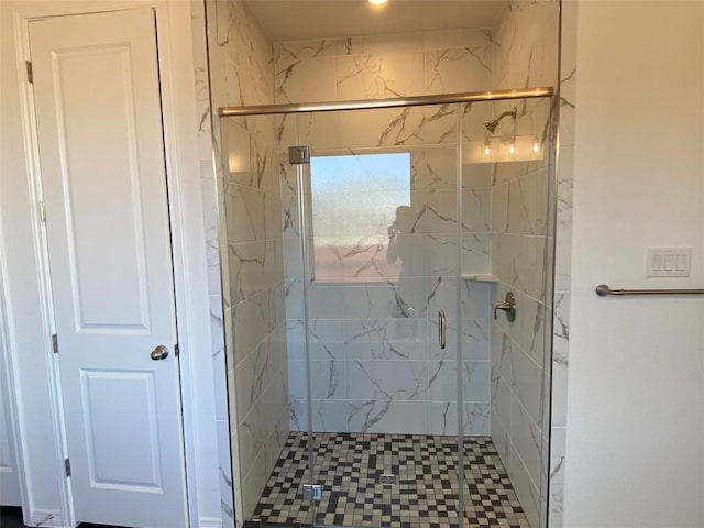 bathroom with a shower with door