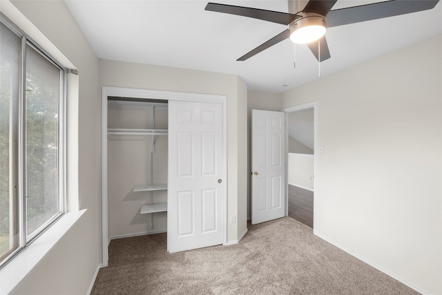 unfurnished bedroom with a closet, light colored carpet, and ceiling fan