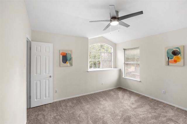 carpeted spare room featuring ceiling fan and vaulted ceiling