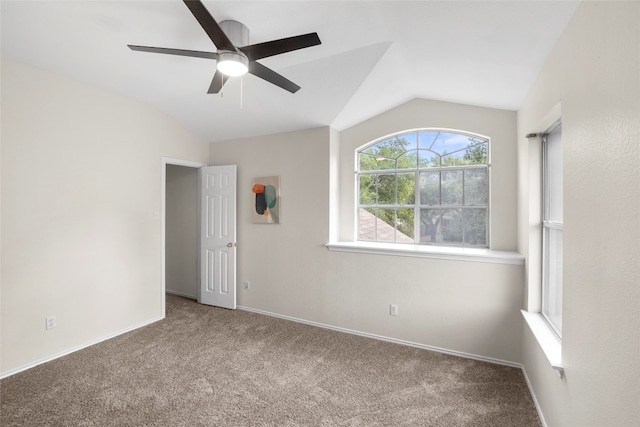 carpeted spare room featuring ceiling fan and vaulted ceiling