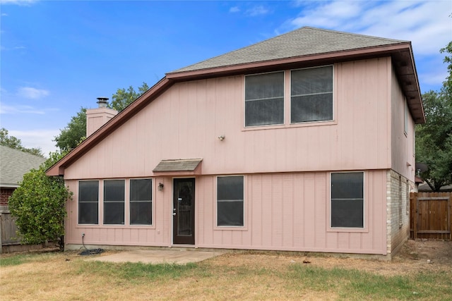 rear view of house with a patio area and a lawn