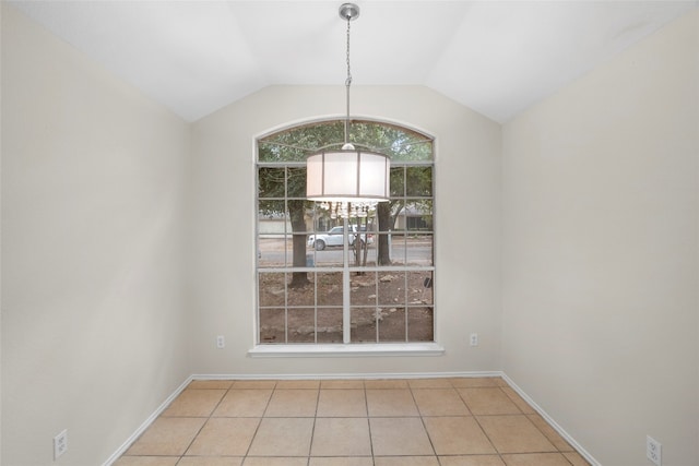 unfurnished dining area featuring a notable chandelier, light tile patterned floors, and vaulted ceiling