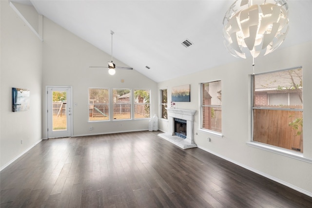 unfurnished living room featuring high vaulted ceiling, ceiling fan with notable chandelier, and dark hardwood / wood-style flooring