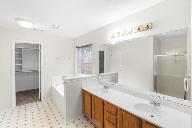 bathroom with vanity and shower with separate bathtub