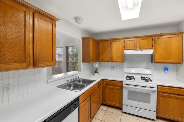 kitchen with white appliances, tasteful backsplash, light tile patterned flooring, and sink