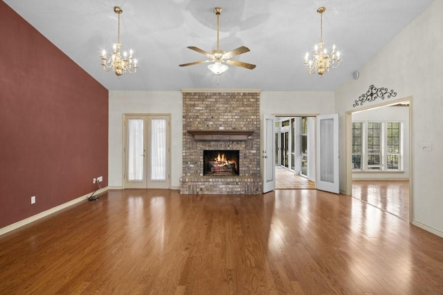300 Delaware Springs Blvd, Burnet, TX 78611 - unfurnished living room with a chandelier, wood finished floors, ceiling fan, french doors, and vaulted ceiling