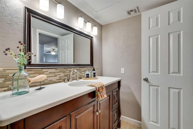 4159 Steck Ave Unit 290, Austin, TX 78759 - bathroom with decorative backsplash, a textured wall, vanity, and baseboards