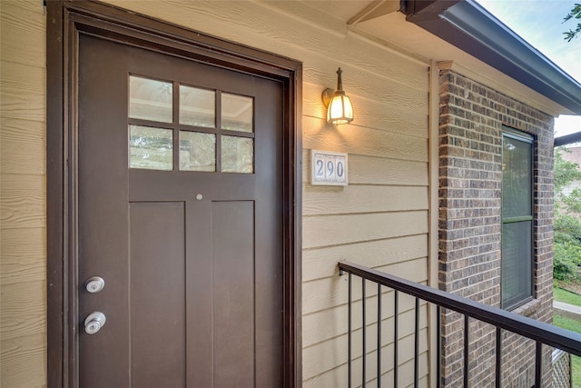 view of exterior entry with a balcony