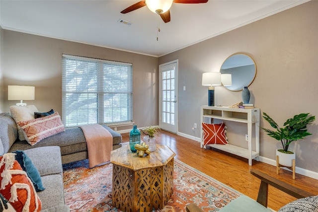 living room featuring crown molding, hardwood / wood-style flooring, and ceiling fan