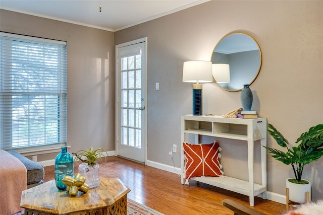 sitting room featuring crown molding, wood-type flooring, and plenty of natural light