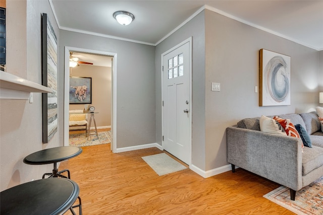 entrance foyer featuring crown molding, light wood-type flooring, and ceiling fan