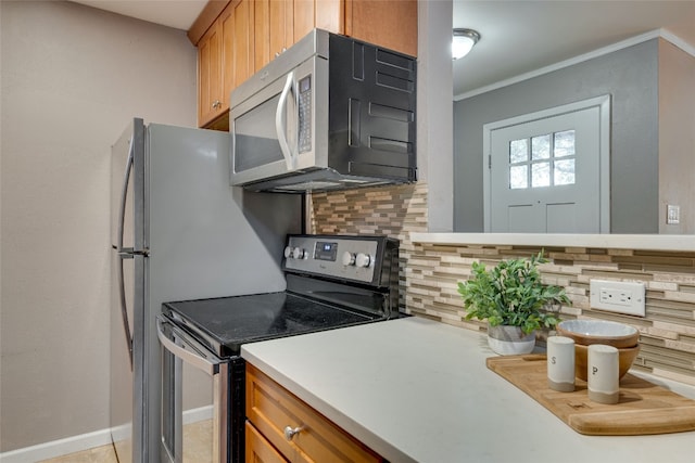 kitchen featuring appliances with stainless steel finishes, ornamental molding, and decorative backsplash