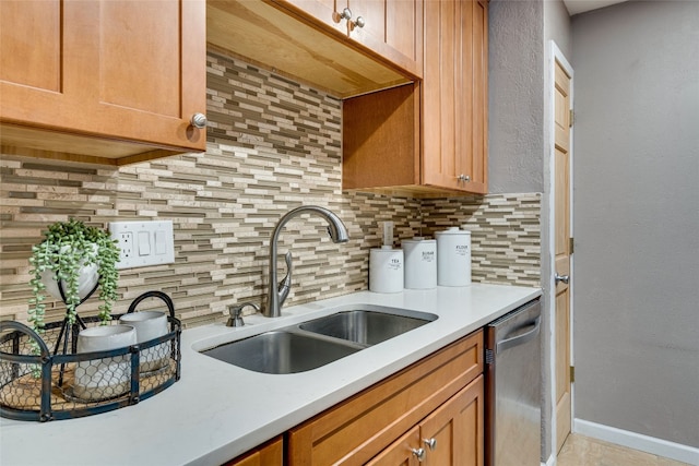 kitchen featuring stainless steel dishwasher, sink, and backsplash