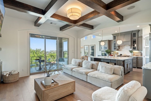 living room featuring light hardwood / wood-style flooring, beam ceiling, and coffered ceiling