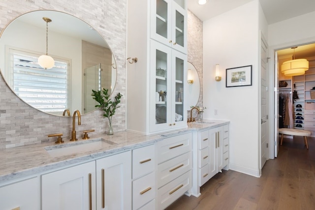 bathroom featuring vanity, hardwood / wood-style floors, decorative backsplash, and a shower with shower door