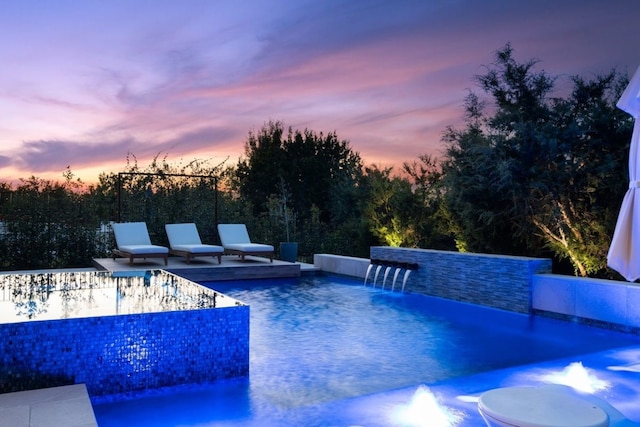 pool at dusk with pool water feature