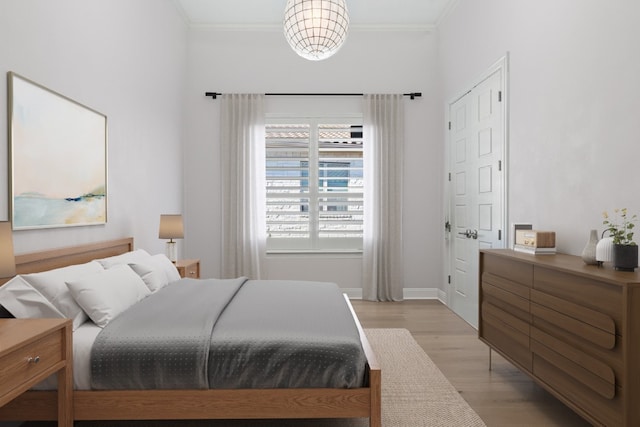 bedroom featuring ornamental molding and light hardwood / wood-style flooring