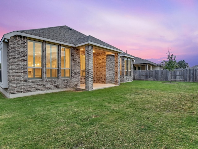 back house at dusk with a yard