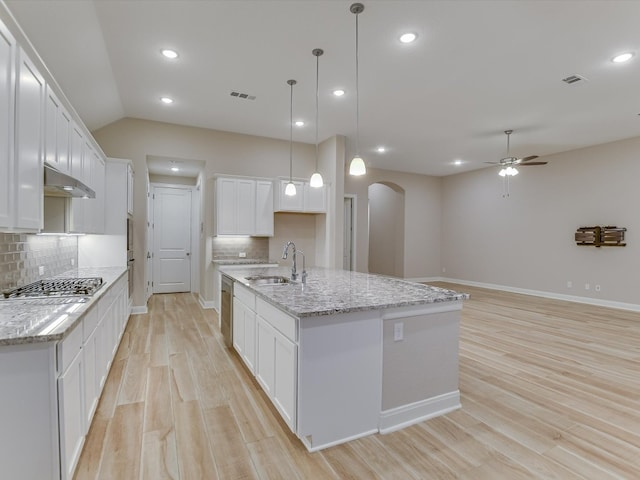 kitchen featuring white cabinetry, pendant lighting, sink, and an island with sink