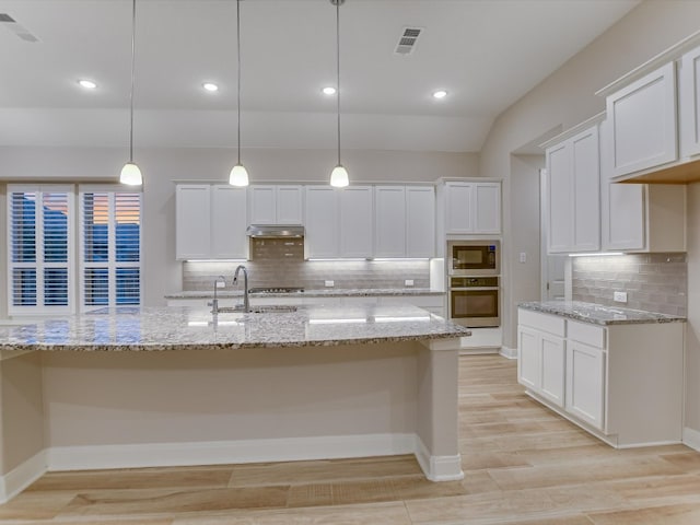 kitchen featuring appliances with stainless steel finishes, white cabinets, sink, and pendant lighting