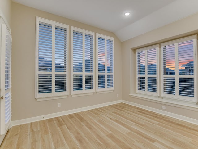 unfurnished room featuring light hardwood / wood-style floors and lofted ceiling