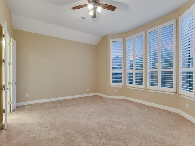 spare room with light carpet, vaulted ceiling, and ceiling fan