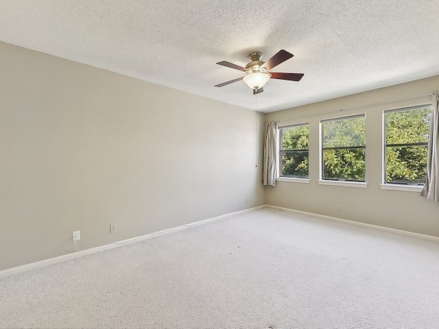 carpeted empty room featuring ceiling fan and a textured ceiling