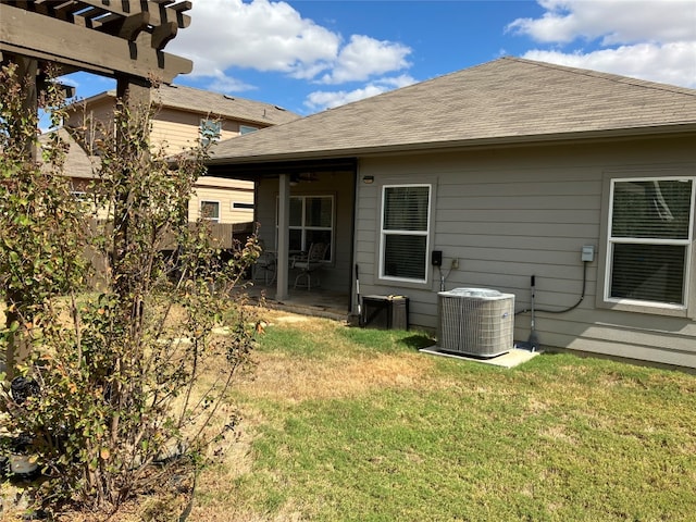 rear view of property with a yard and central AC unit